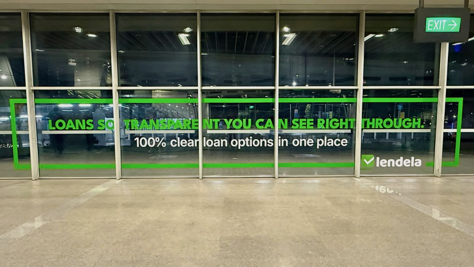 Lendela text on an MRT station window reading "Loans so transparent you can see right through" above "100% clean loan options in one place"