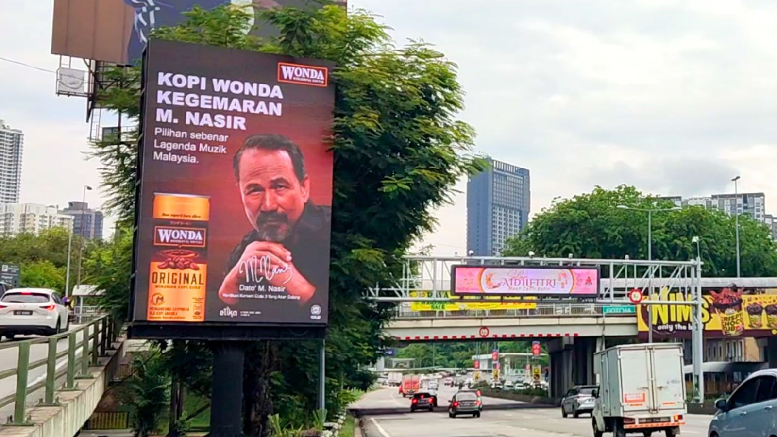 Wonda Coffee highway billboard in Malaysia showing the singer M. Nasir with the headline "Kopi Wonda kegemaran M. Nasir"