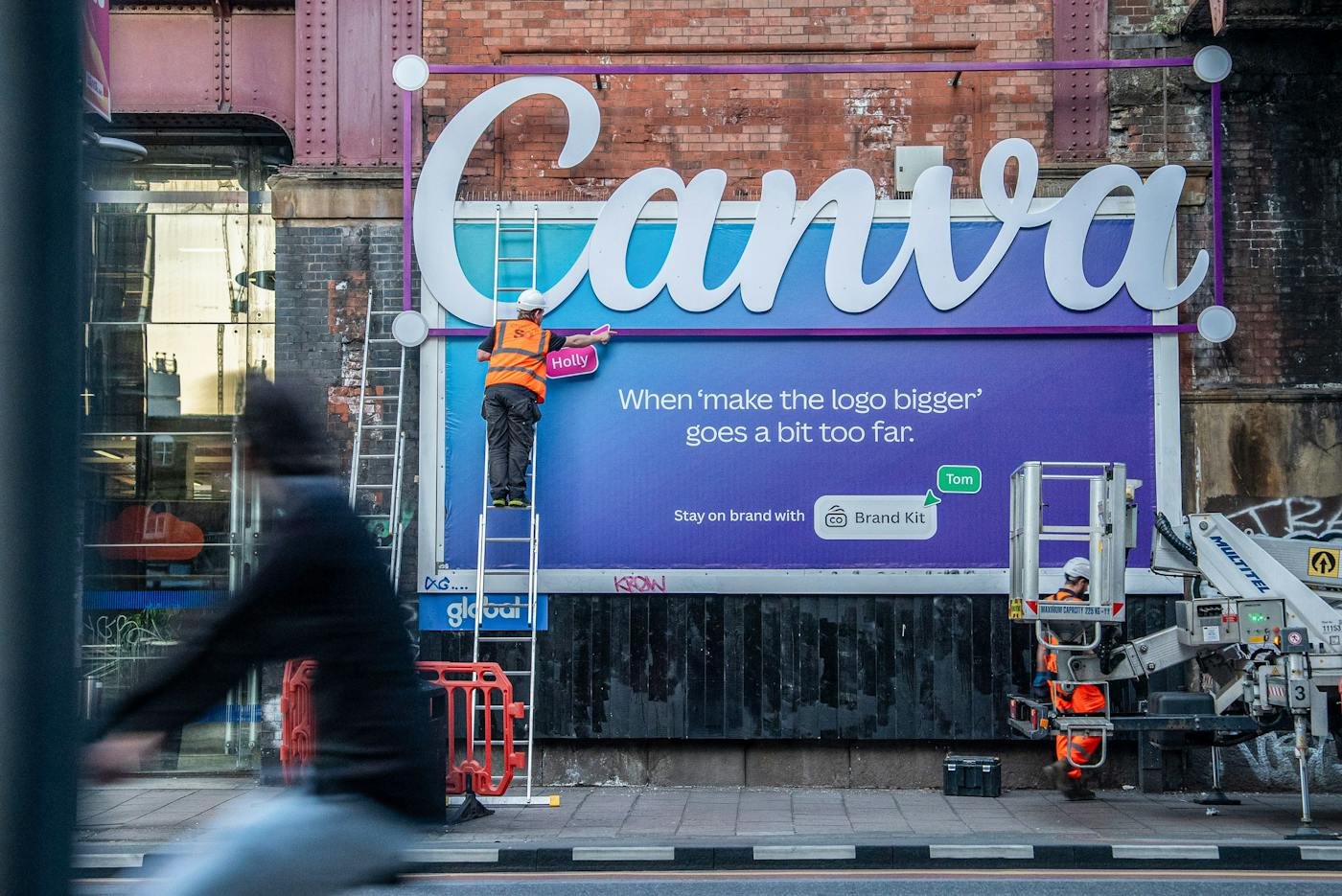 A Canva billboard where a giant three-dimensional Canva logo breaks out above the frame, with the line When make the logo bigger goes a bit too far