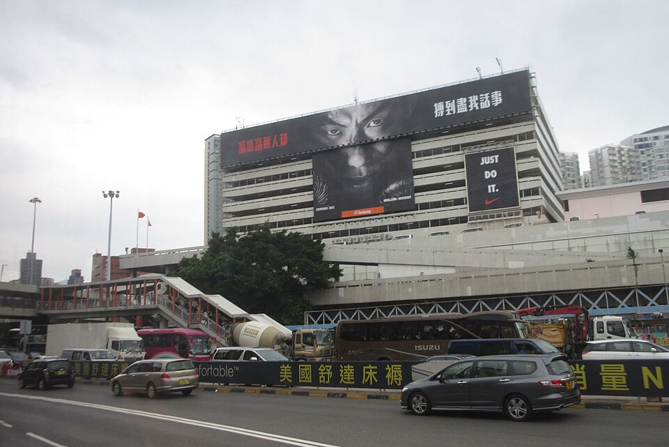 A large Nike Just Do It outdoor advertisement on a train station facade featuring boxer Rex Tso