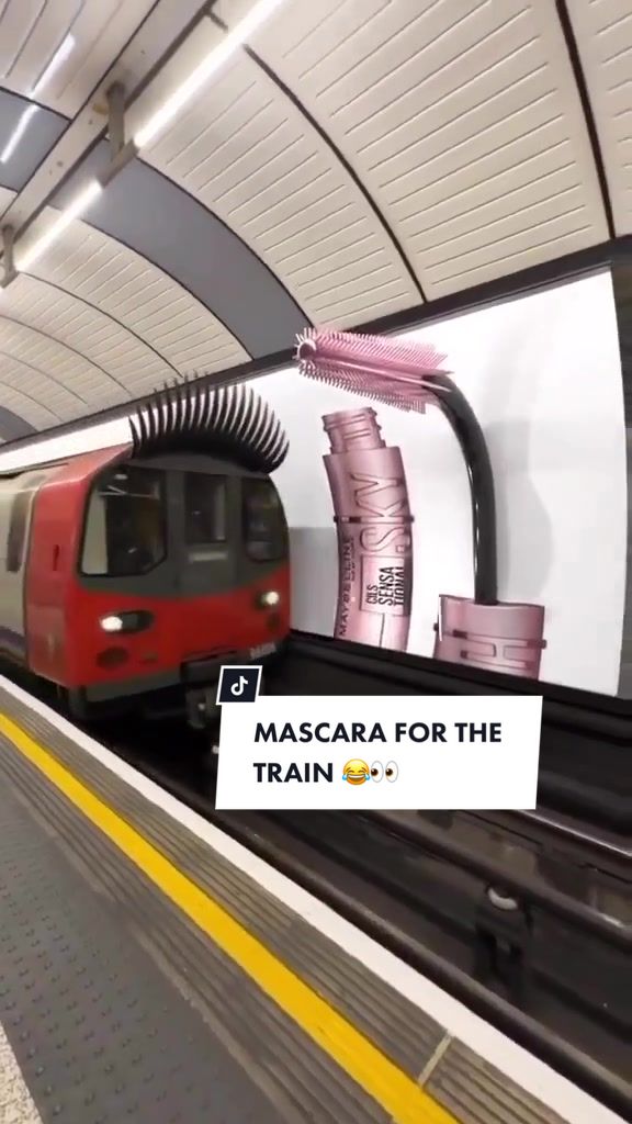 London Underground train wearing giant CGI eyelashes beside a billboard of a Sky High mascara tube and wand