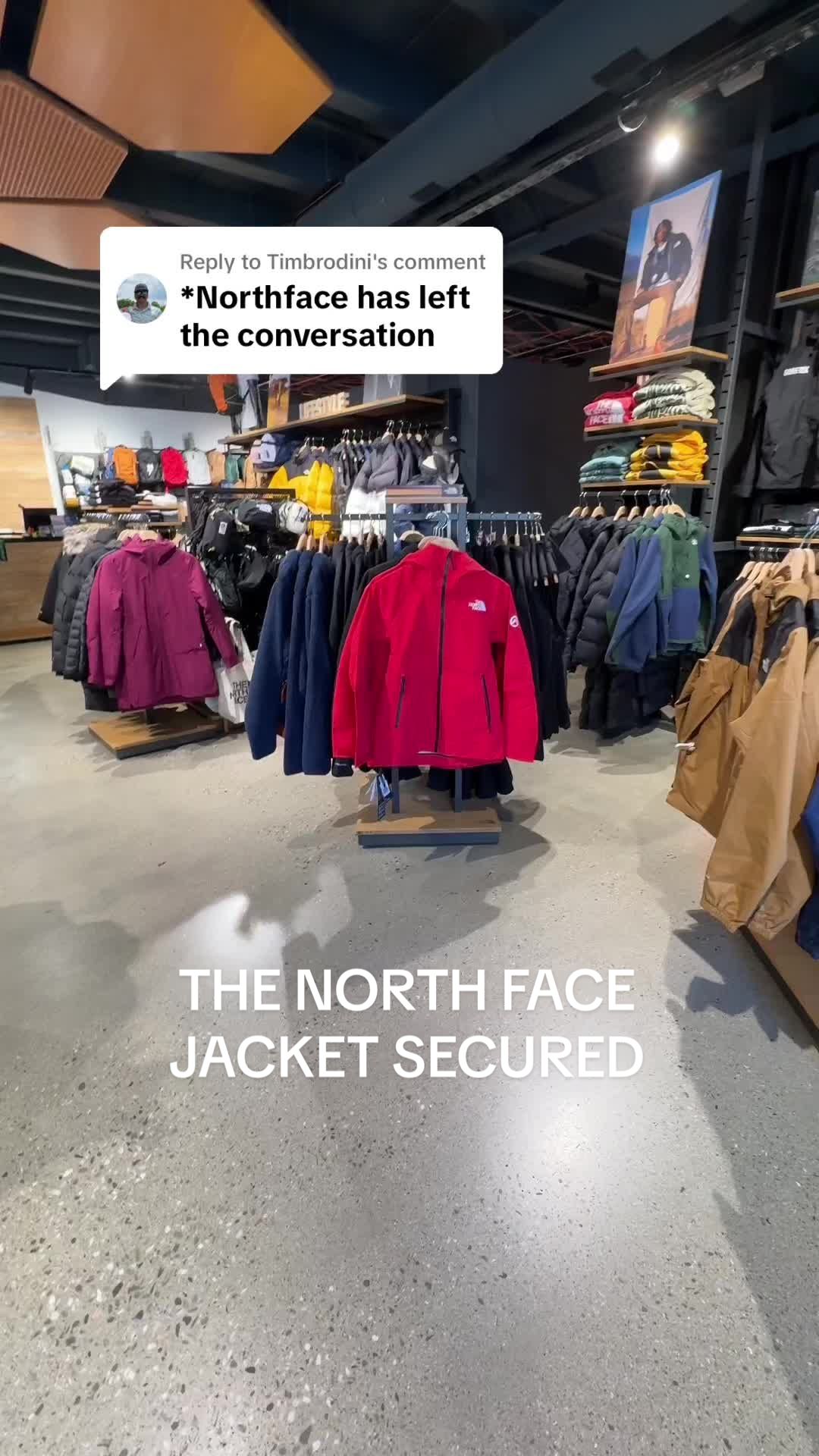 North Face employee collecting a red jacket in a store, with the caption The North Face jacket secured