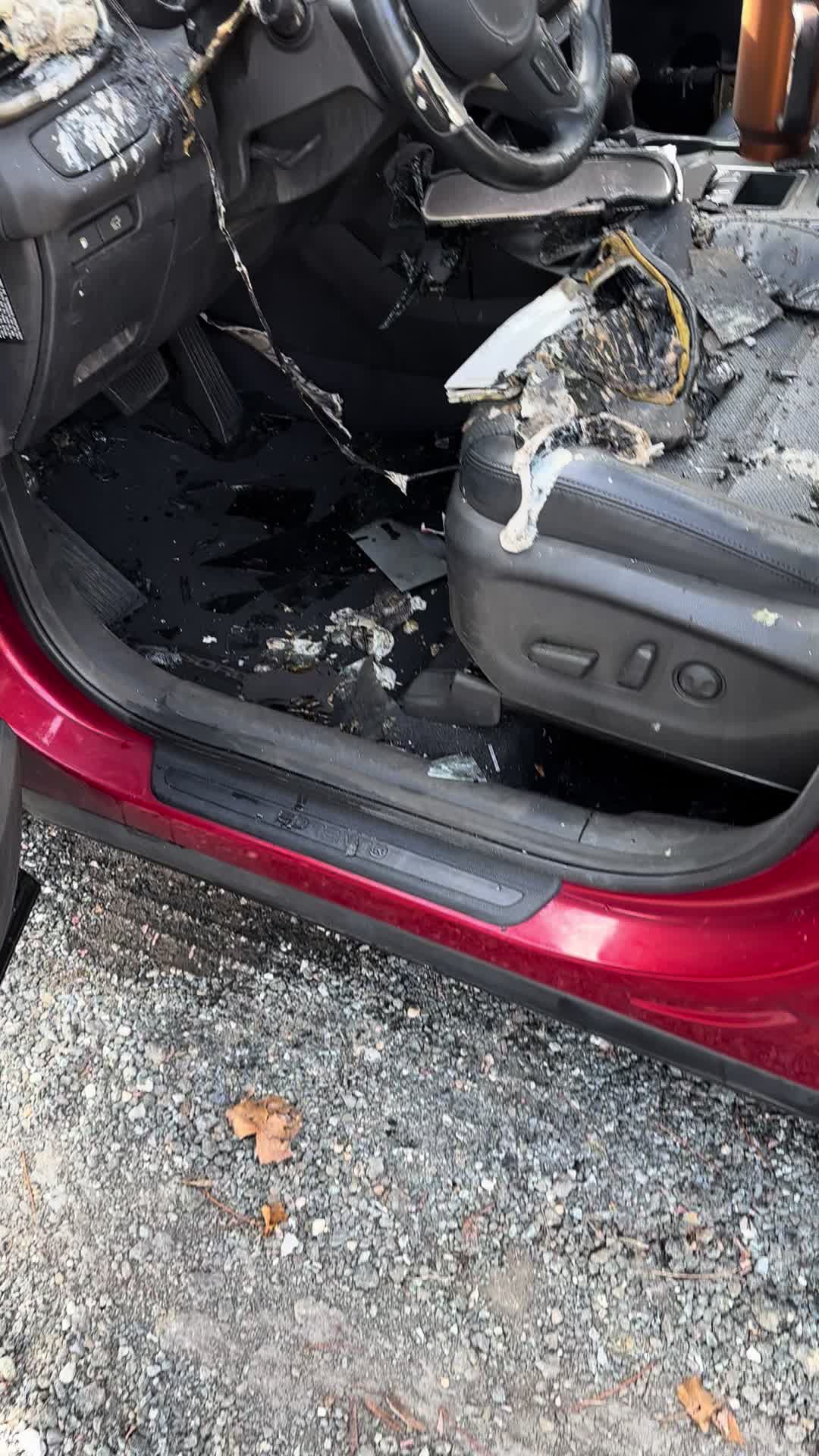 Burned-out car interior with a Stanley Quencher tumbler still standing in the console